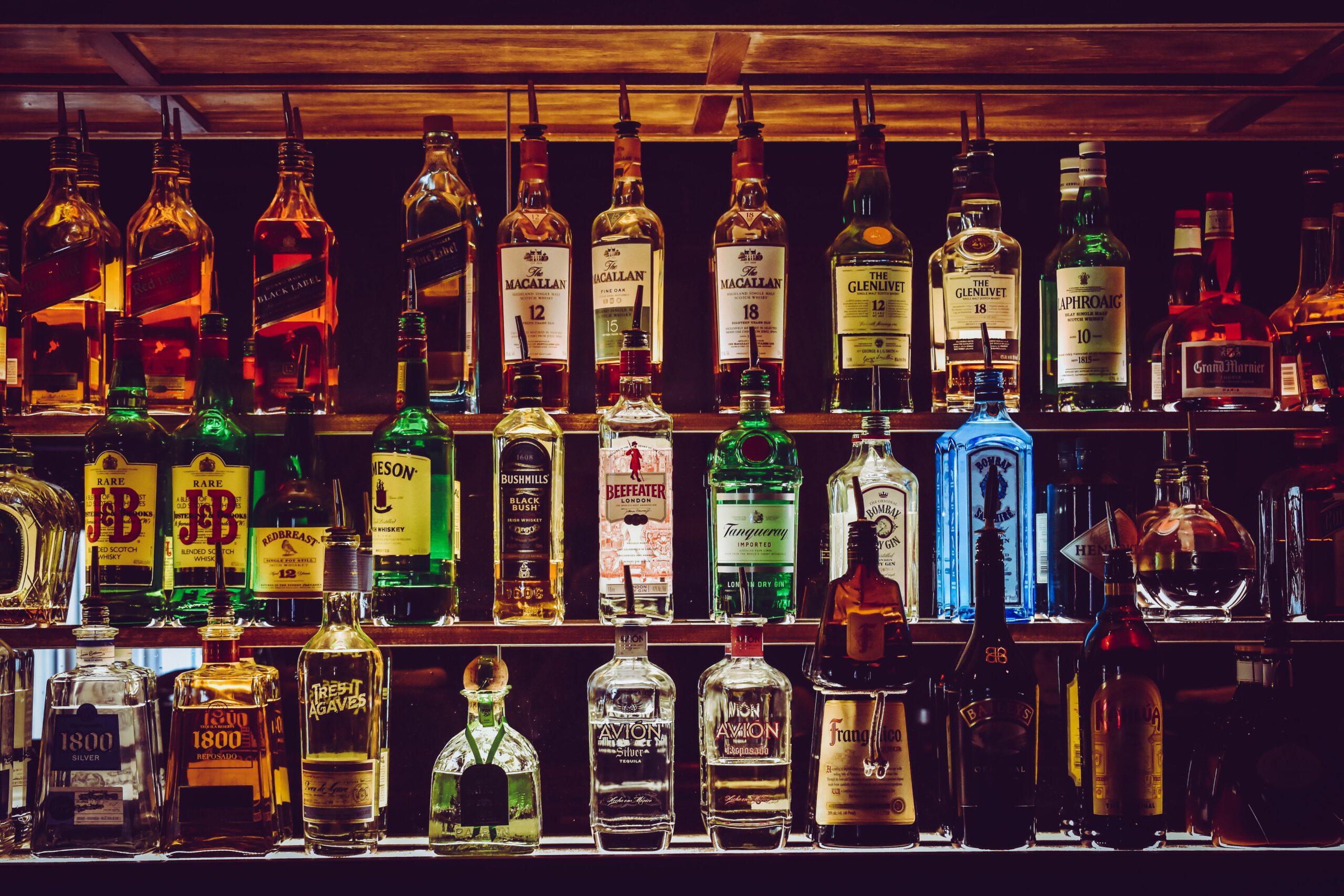 Home An array of various liquor bottles beautifully displayed on a bar shelf.